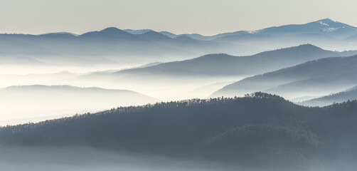 Silhouettes of mountains in the sea of fog in winter.