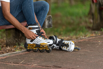 Close-up of young man putting on inline skates