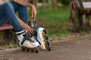 Close-up of young man putting on inline skates