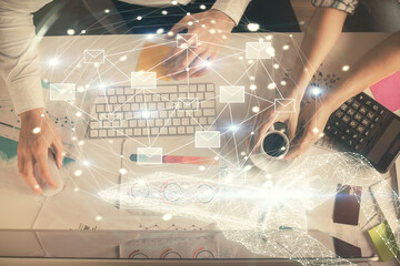 Double exposure of man and woman working together and the envelop hologram drawing. Computer background. Top View. Electronic mail concept.
