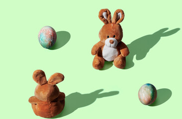 soft toy bunny with easter egg on green pastel background