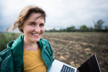 Farmer with laptop on the field. Smart farming and agriculture digitalization	