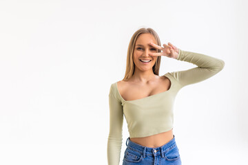 Happy young woman showing peace sign with both hands over white background