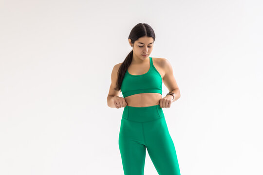 Fitness Woman Lost Weight And Her Trousers Are Too Big On White Background