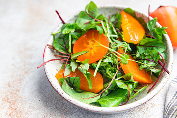 persimmon salad lettuce green leaves mix healthy meal food snack on the table copy space food background vegan or vegetarian food