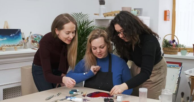 Girls young women prepare for Valentine's Day, crafting handmade gifts for their husbands and boyfriends. Making big painted heart as a present for beloved for St. Valentine Day