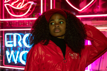 Fototapeta premium portrait of an African American young woman in sunglasses isolated on a neon light background 
