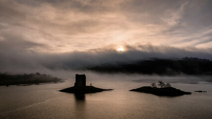 Castle Stalker aerial silhouette view of the castle and island near Appin and Glencoe in the Scottish Highlands. Landscape photography 