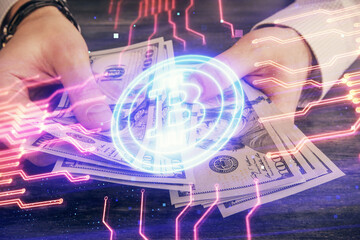 Obraz premium Multi exposure of blockchain theme drawing hologram and USA dollars bills and man hands. Business concept.