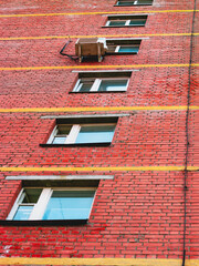 red brick wall with windows and yellow stripes