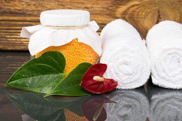 two white towels and orange bath salt for spa treatments, background