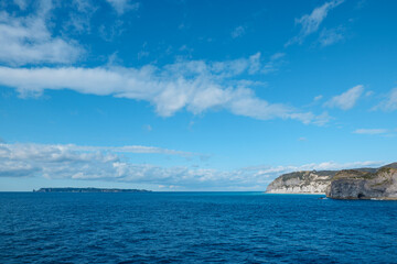 Fototapeta na wymiar クルーズ船から見た新島の白ママ断崖と遠くに見える式根島
