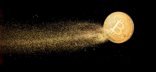 Gold bitcoin with visible gold shining comet tail ath the dark background. Conceptual picture of digital money.