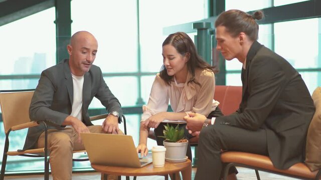 Office workers, Creative business team, coworking space. Creative business team of three people discussing business plan while sitting at table in modern office, company 