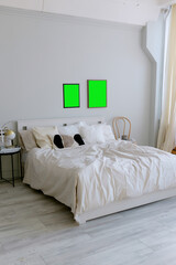Bedroom in scandinavian minimalist style. Gray walls. Paintings on the wall. Clothes hanger with shirts