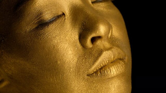 Closeup Of Lady's Face With Golden Skin On Black Background