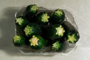 Dark green zucchini stacked on a white background.