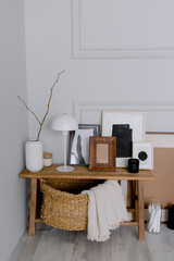 Obraz premium Wooden bench in the room Scandinavian style interior accessories Lamp and vase with photo frames Wicker basket with plaid for decor