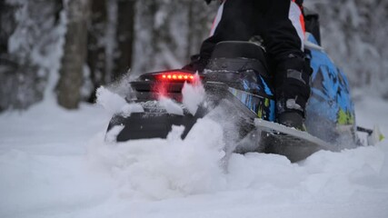 sports snowmobile rides and jumps in the snow in the forest - Powered by Adobe