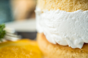 Two cake layers with white cream in center focus on the right side of picture
