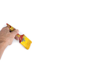 Old used yellow brush in the hand on a blank canvas