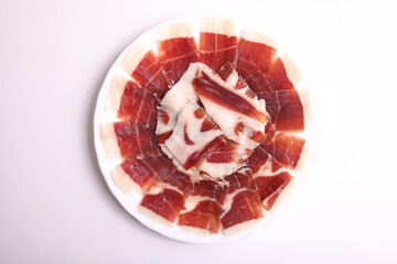 Portion of acorn-fed Iberian ham 100% Dehesa de Extremadura with base and plate decorated with...