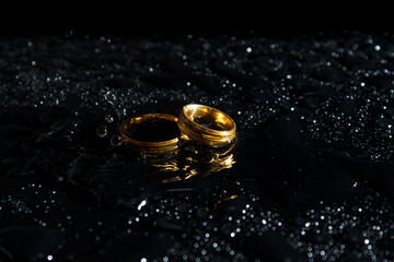 Obraz na płótnie Canvas Rings on a dark background. Wedding rings. Jewelry. Splashes of water.