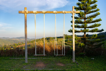Fototapeta na wymiar Swings Set with Mountain and Blue Sky