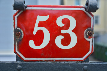 A red number plaque, showing the number fifty-three, 53