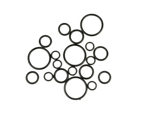 Background of o-rings and gaskets in black on a white background. Hydraulic and pneumatic o-rings in black in different sizes on a white background. Various seals for plumbing.
