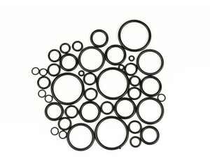 Background of o-rings and gaskets in black on a white background. Hydraulic and pneumatic o-rings in black in different sizes on a white background. Various seals for plumbing. 