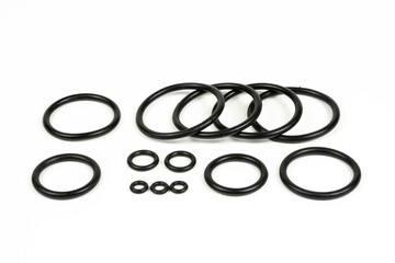 Hydraulic and pneumatic o-rings in black in different sizes on a white background. Various seals for plumbing. Sealing rings for hydraulic connections.