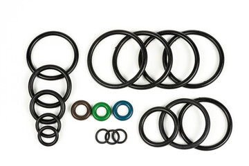 Hydraulic and pneumatic o-rings in black in different sizes on a white background. Various seals...