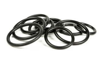 Black hydraulic and pneumatic o-rings in different sizes on a white background. O-rings for hydraulic connections. Rubber seals for sanitary ware. Copy space