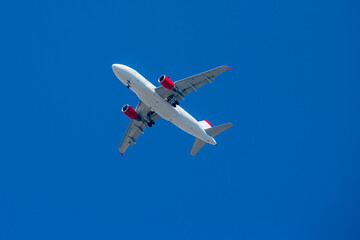 Passenger airplane. View exactly from below, silhouette against the blue sky in Austria.