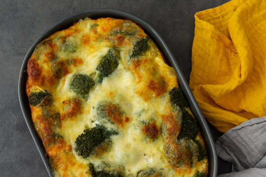 Frittata with chicken breast and broccoli in an oval dish, egg omelette with vegetables, cheese and chicken, top view