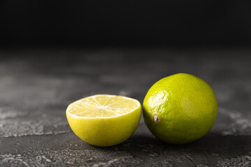 Lime, juicy ripe citrus fruits on a dark background. Ingredients for preparing refreshing drinks and cocktails. Mojito. Selective focus, top view and copy space