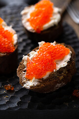 Appetizer with red caviar, cream cheese and rye bread