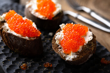 Appetizer with red caviar, cream cheese and rye bread