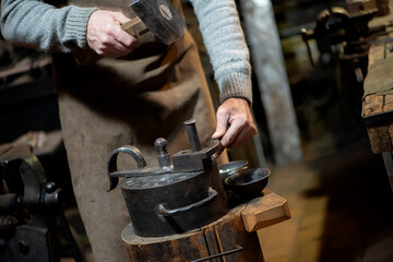 Coinage craftsman stamping coins with hammer and anvil. Vintage style handicraft concept