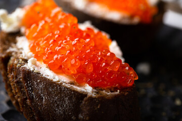 Appetizer with red caviar, cream cheese and rye bread