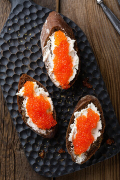Appetizer with red caviar, cream cheese and rye bread