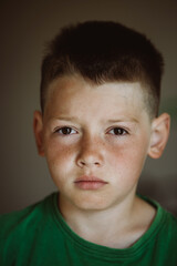 Cute caucasian sleepy blond boy just wake up and looking angry after sleep