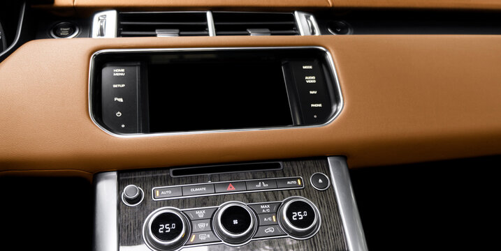 Brown luxury modern car Interior. Shift lever and dashboard. Detail of modern car interior. Automatic gear stick. Part of leather seats with stitching in expensive car