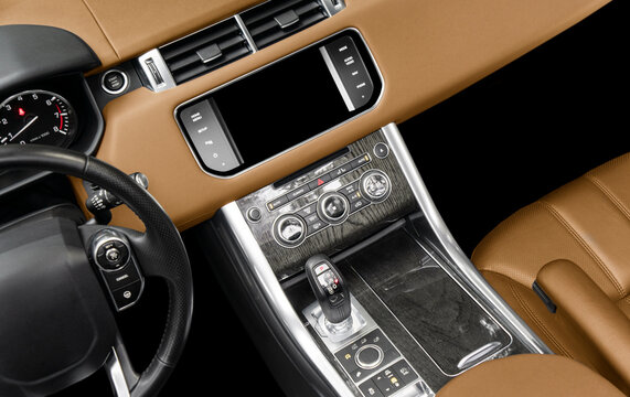 Brown luxury modern car Interior. Steering wheel, shift lever and dashboard. Detail of modern car interior. Automatic gear stick. Part of leather seats with stitching in expensive car