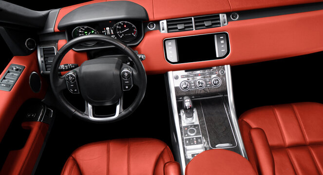 Red luxury modern car Interior. Steering wheel, shift lever and dashboard. Detail of modern car interior. Automatic gear stick. Part of red leather seats with stitching in expensive car