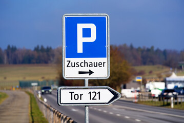 Traffic sign showing direction for car park near the runway of the airport. Translation for text Zuschauer (German) is spectators. Photo taken January 13th, 2022, Zurich, Switzerland.