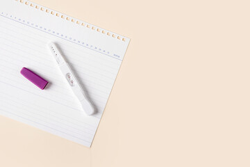 A positive pregnancy test kit is placed on the calendar