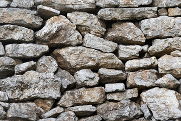 Stone wall. Rock background of crushed rocks stacked on top of each other.