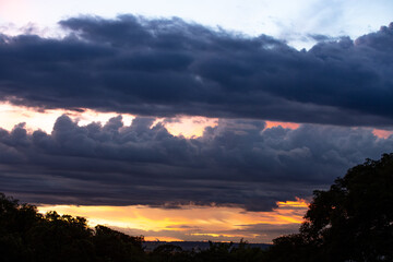 Dramatic sky with dark clouds and a background of blue and orange sky at dawn